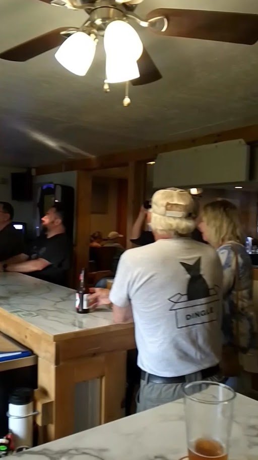 Restaurant space with booths beside a long service bar.
